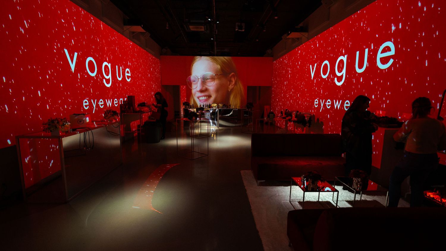 Dramatic red-lit venue with Vogue signage and atmospheric lighting effects.