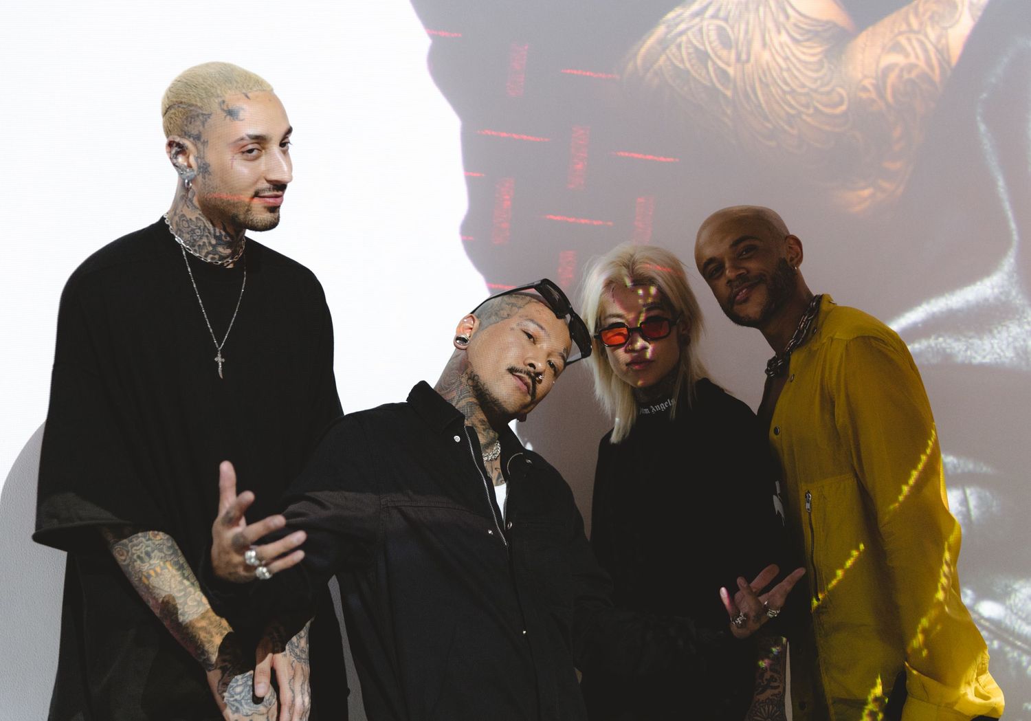 Group of performers on stage during artistic event with projected backdrop.