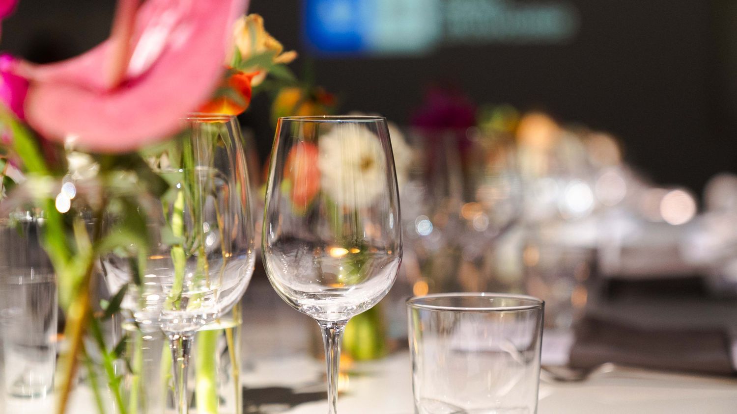 Wine glasses and floral arrangements set on an elegant dining table.