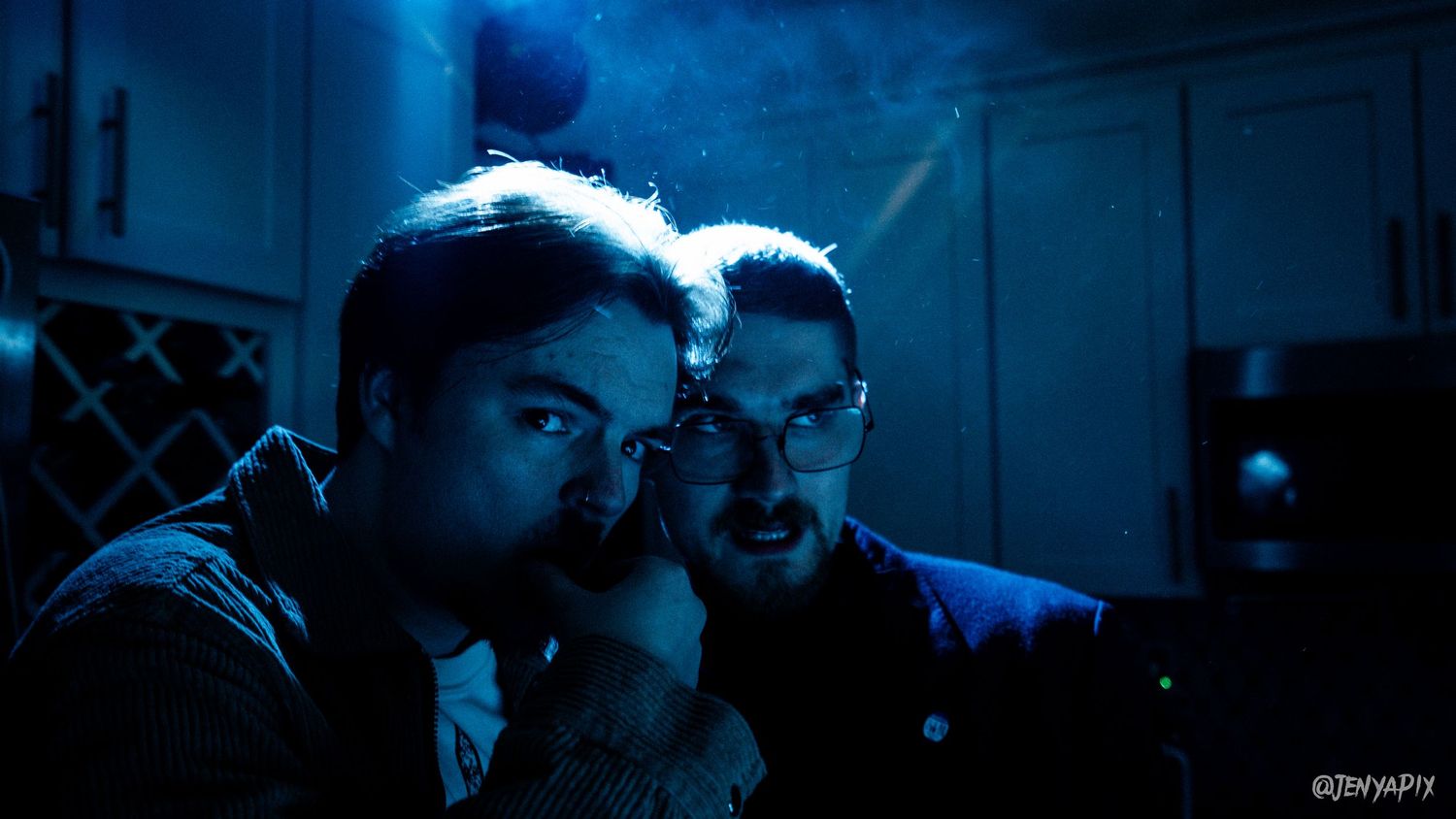 Atmospheric blue-tinted photo of people in a dark room.