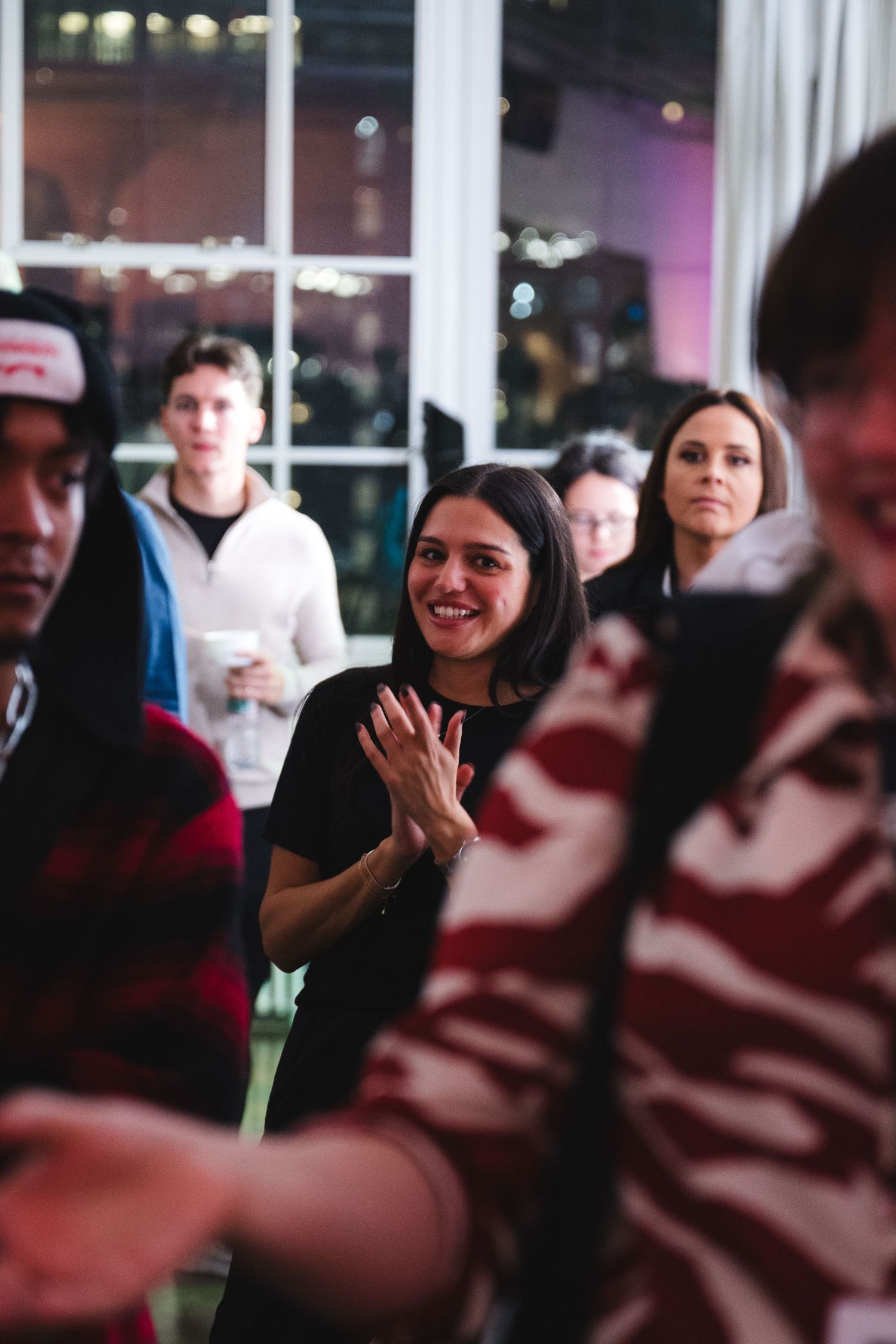 An enthusiastic audience member claps during an indoor event.