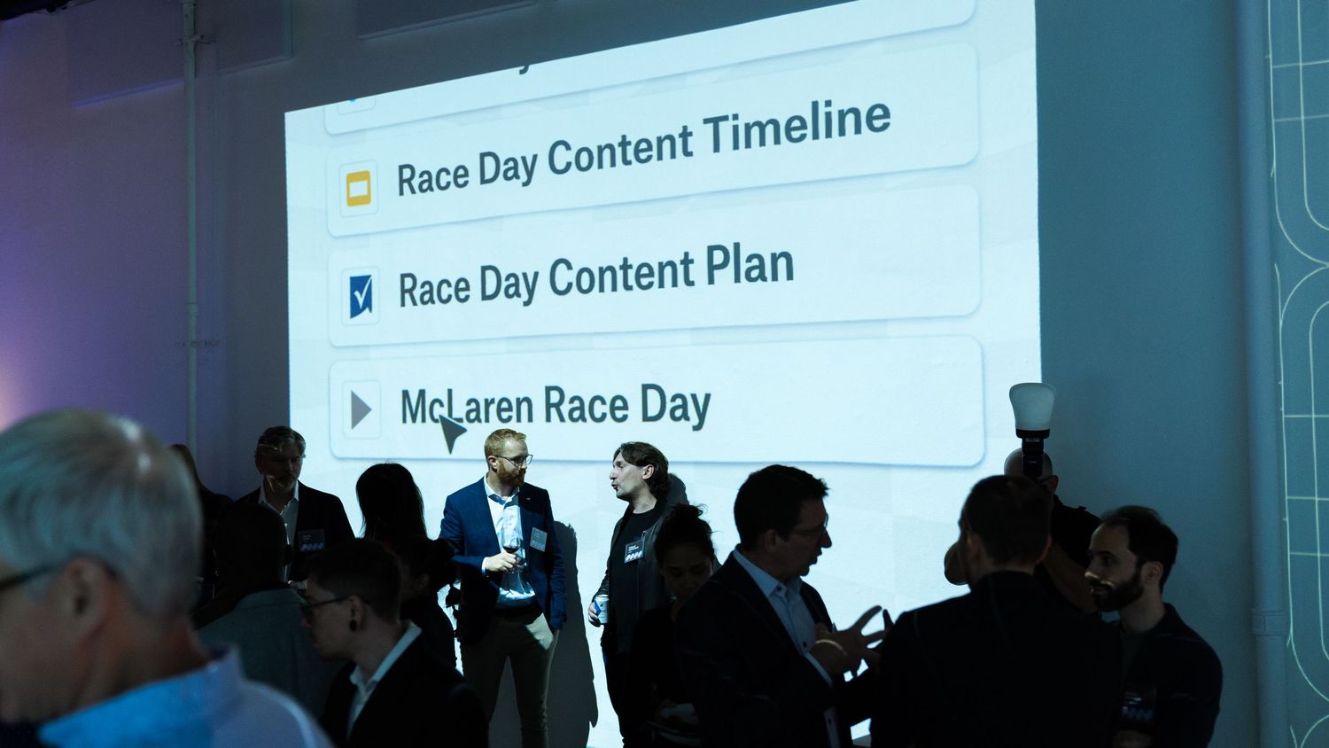 Business presentation showing Race Day content timeline on projector screen.