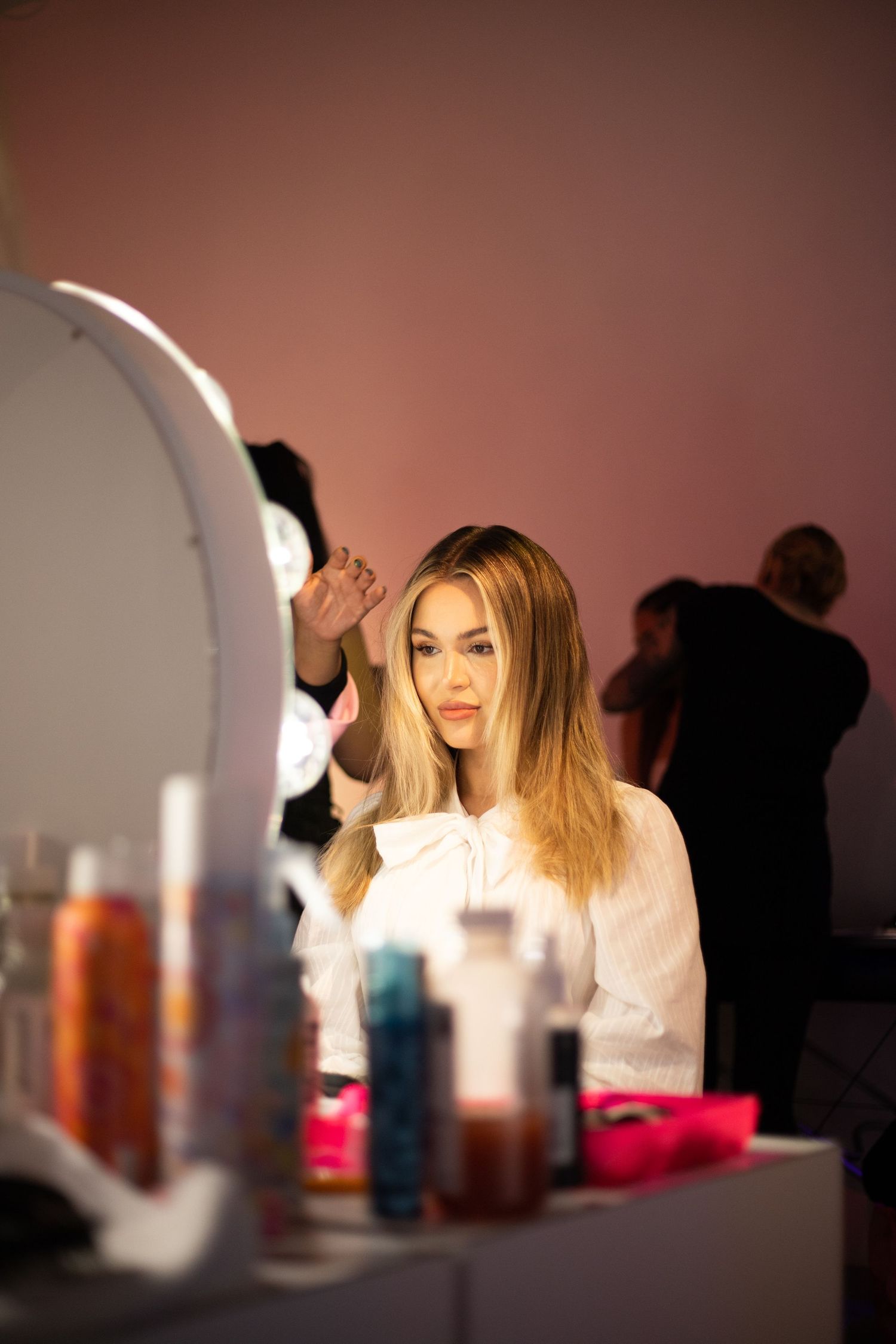 Stylish makeup station with illuminated mirror and hair products on display.