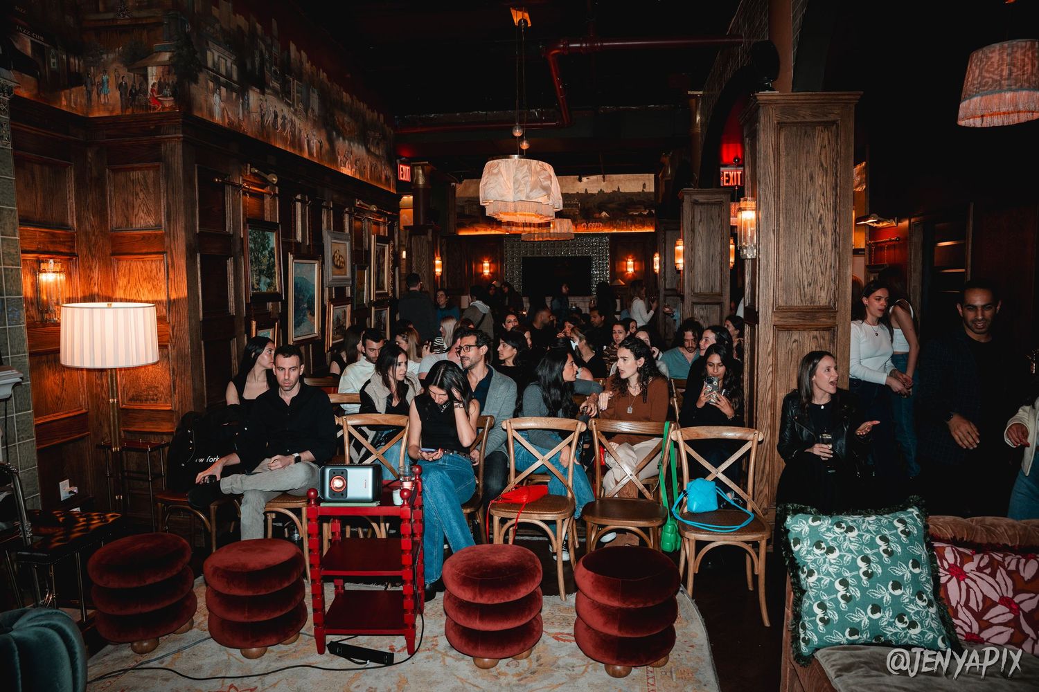 Venue interior with rows of vintage chairs and ambient lighting.