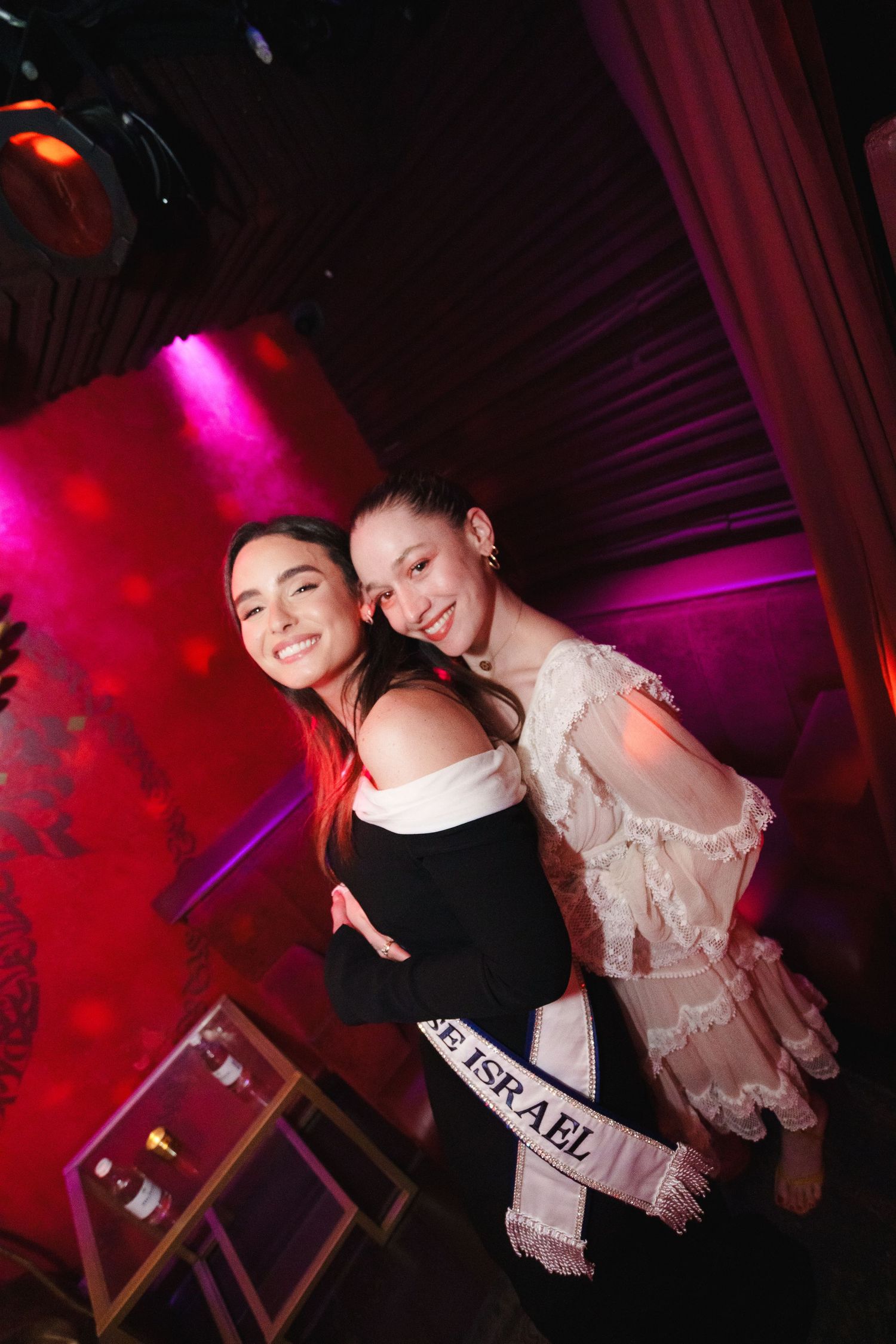 Nightclub party scene with pink and red lighting effects and disco ball.
