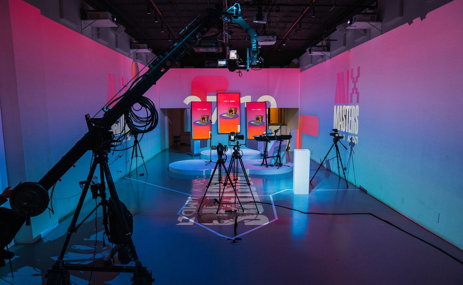 Professional video studio setup with colorful gradient lighting and multiple camera equipment.