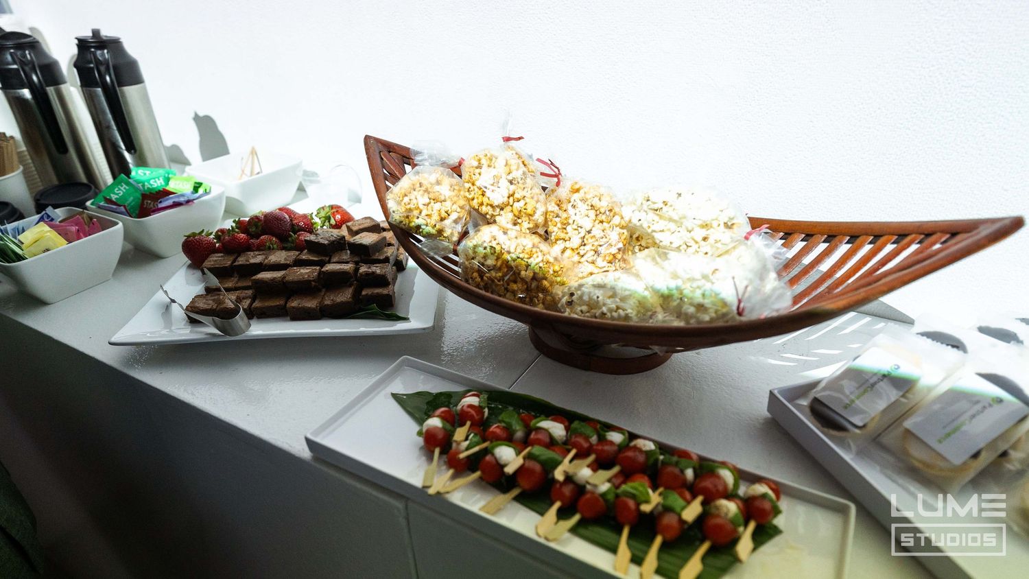 Buffet table with boat-shaped serving dishes containing appetizers and snacks.