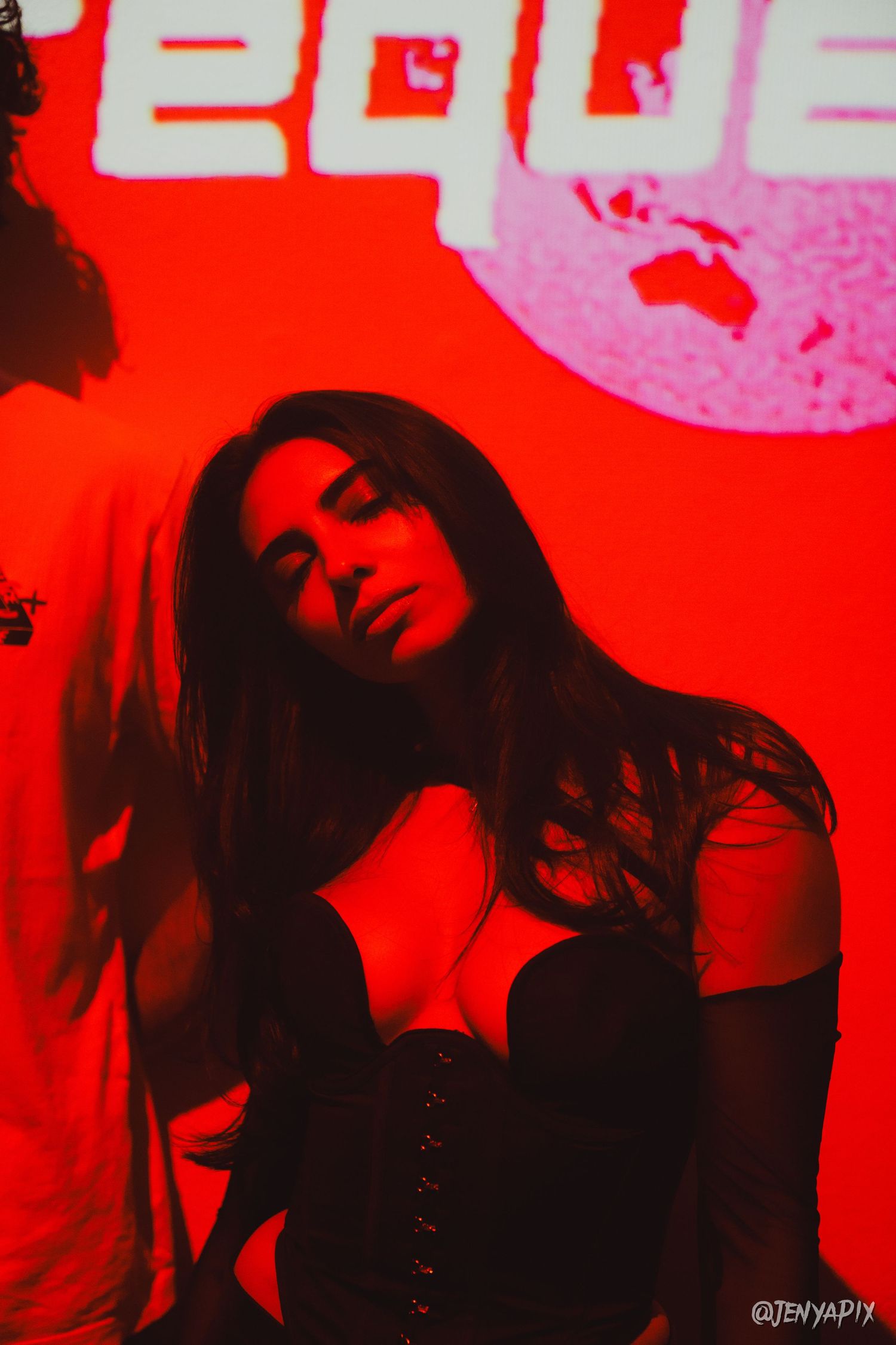 Artistic portrait in red lighting against graphic background.