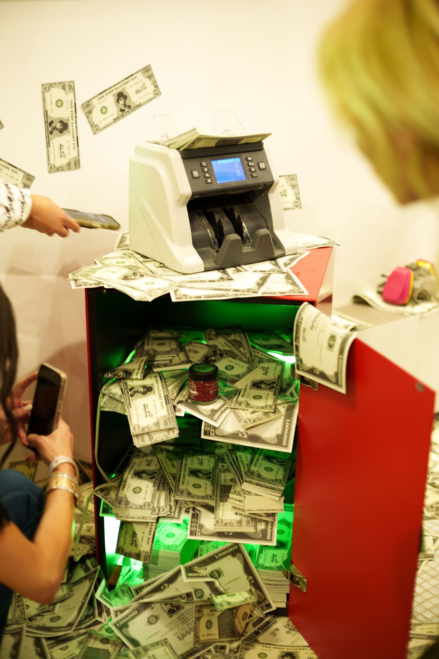 Money counter machine with cash scattered around it in bright lighting.