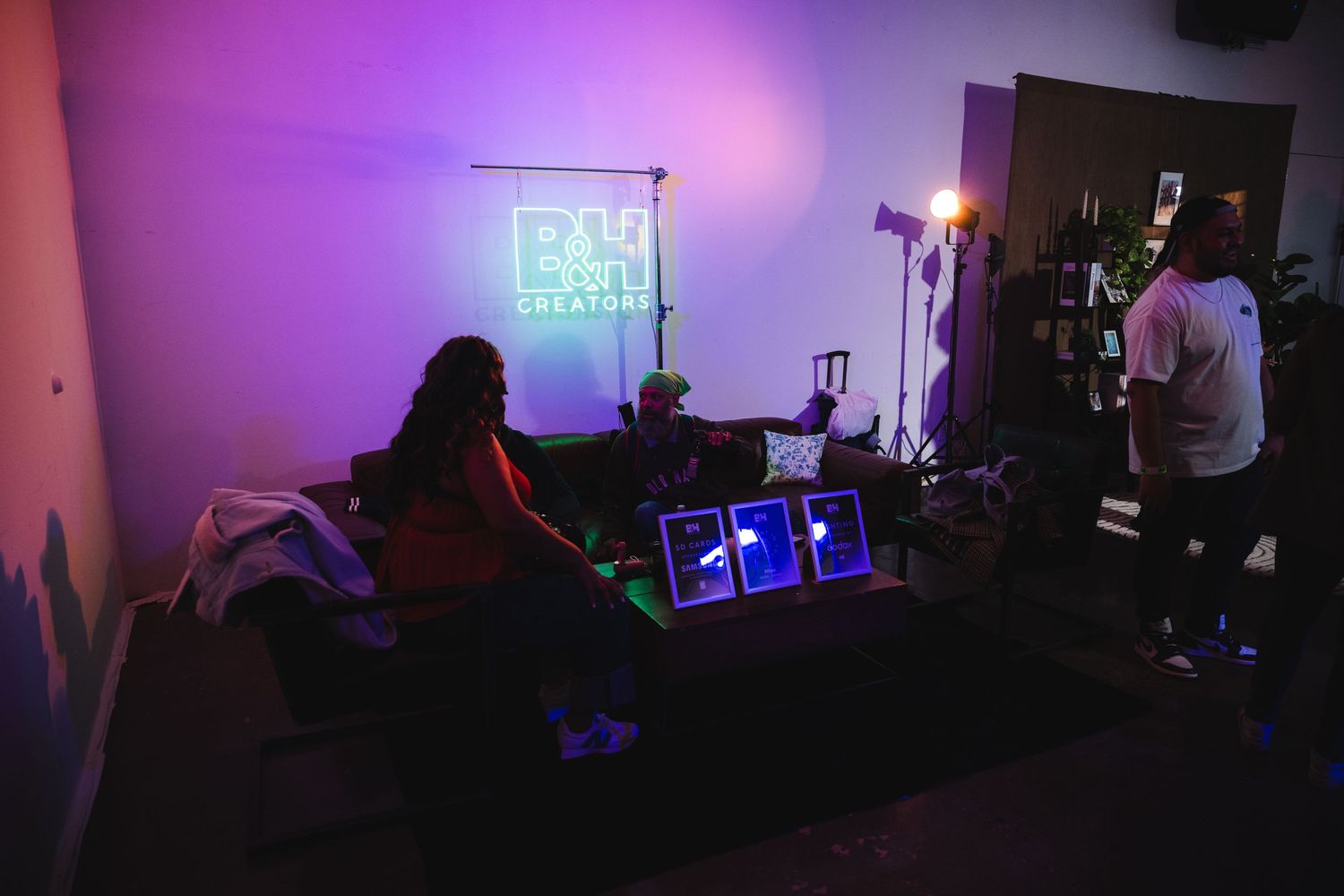 Dark room with purple ambient lighting and neon sign visible in background.