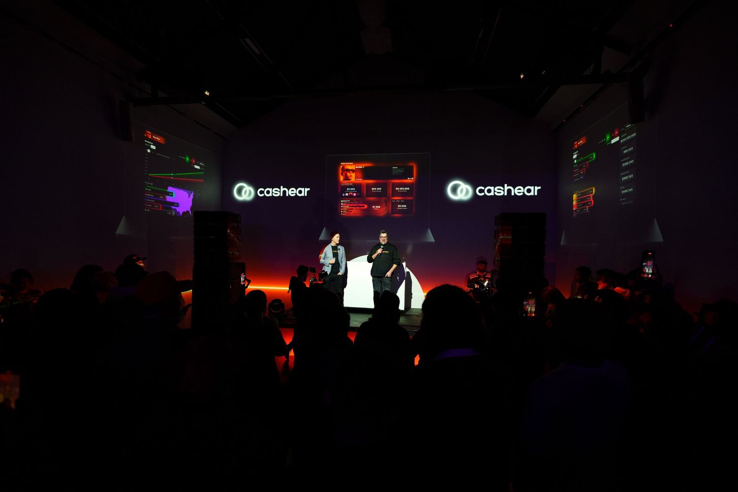 Concert venue with digital screens displaying Cashapp logos while performers entertain on dark stage.