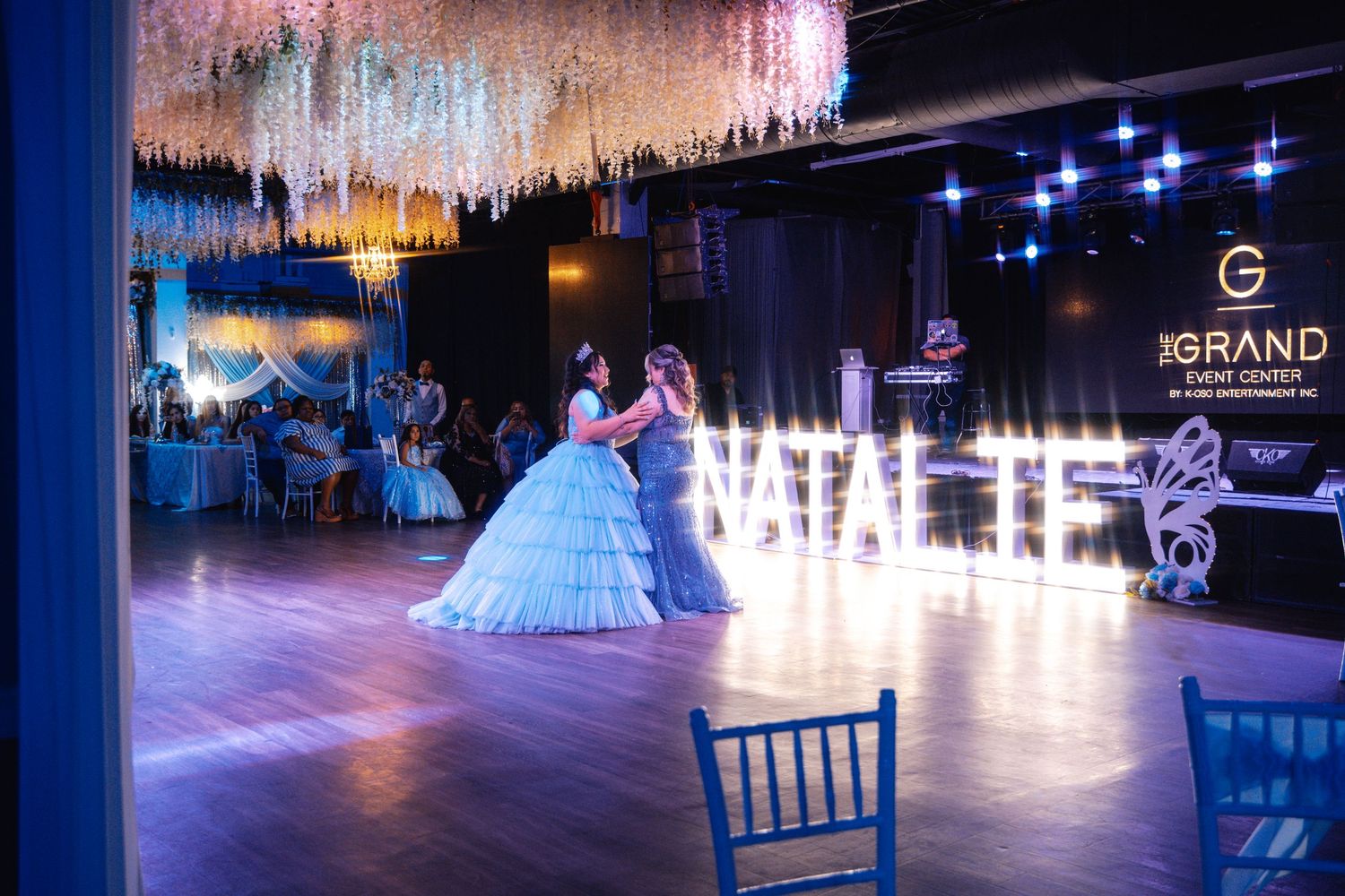 A grand ballroom decorated with crystal chandeliers and elegant lighting for an evening wedding reception.