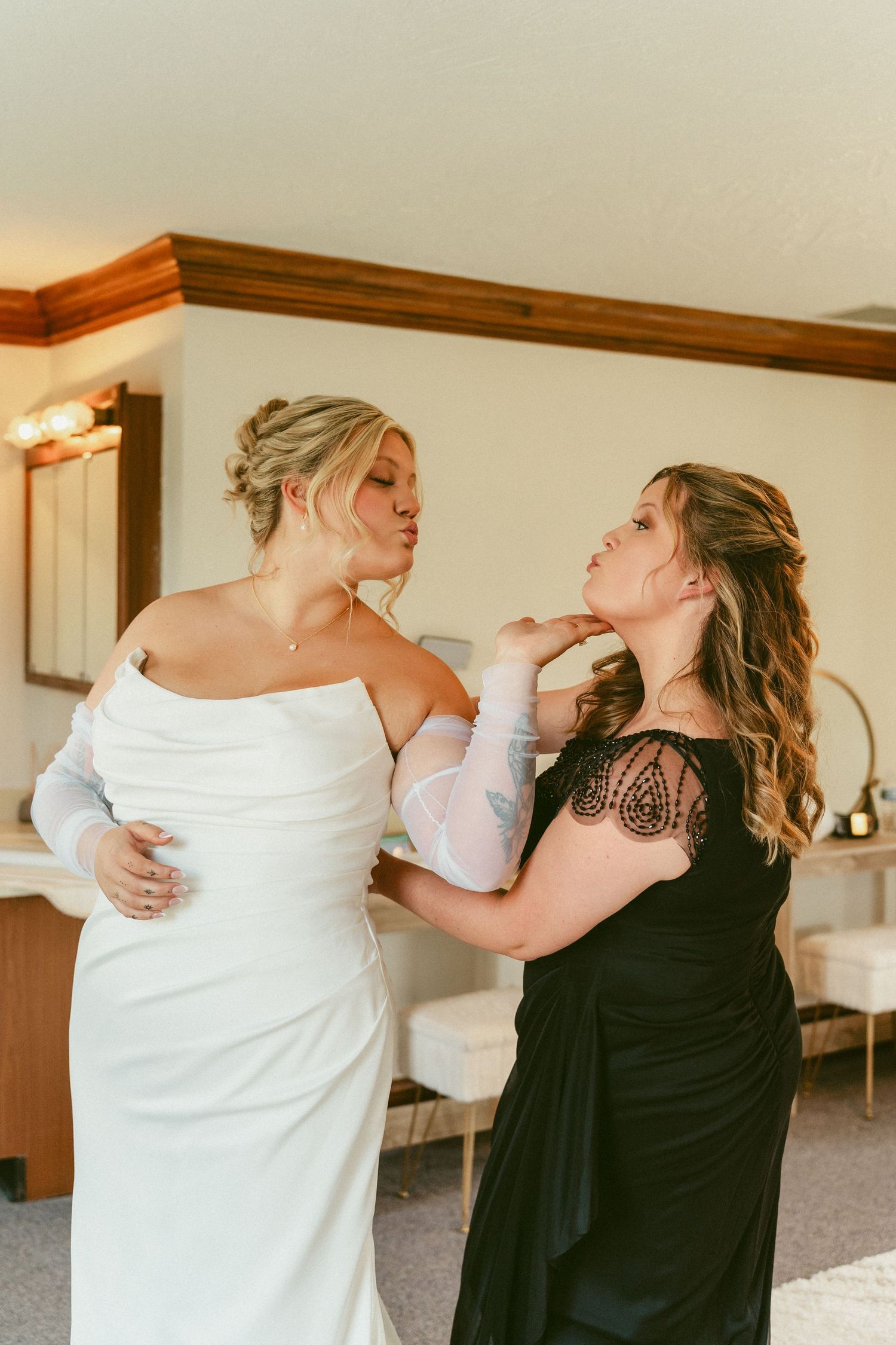 Two people in contrasting black and white outfits share a playful dance moment together in an indoor setting. Located in Bellbrook, Ohio.