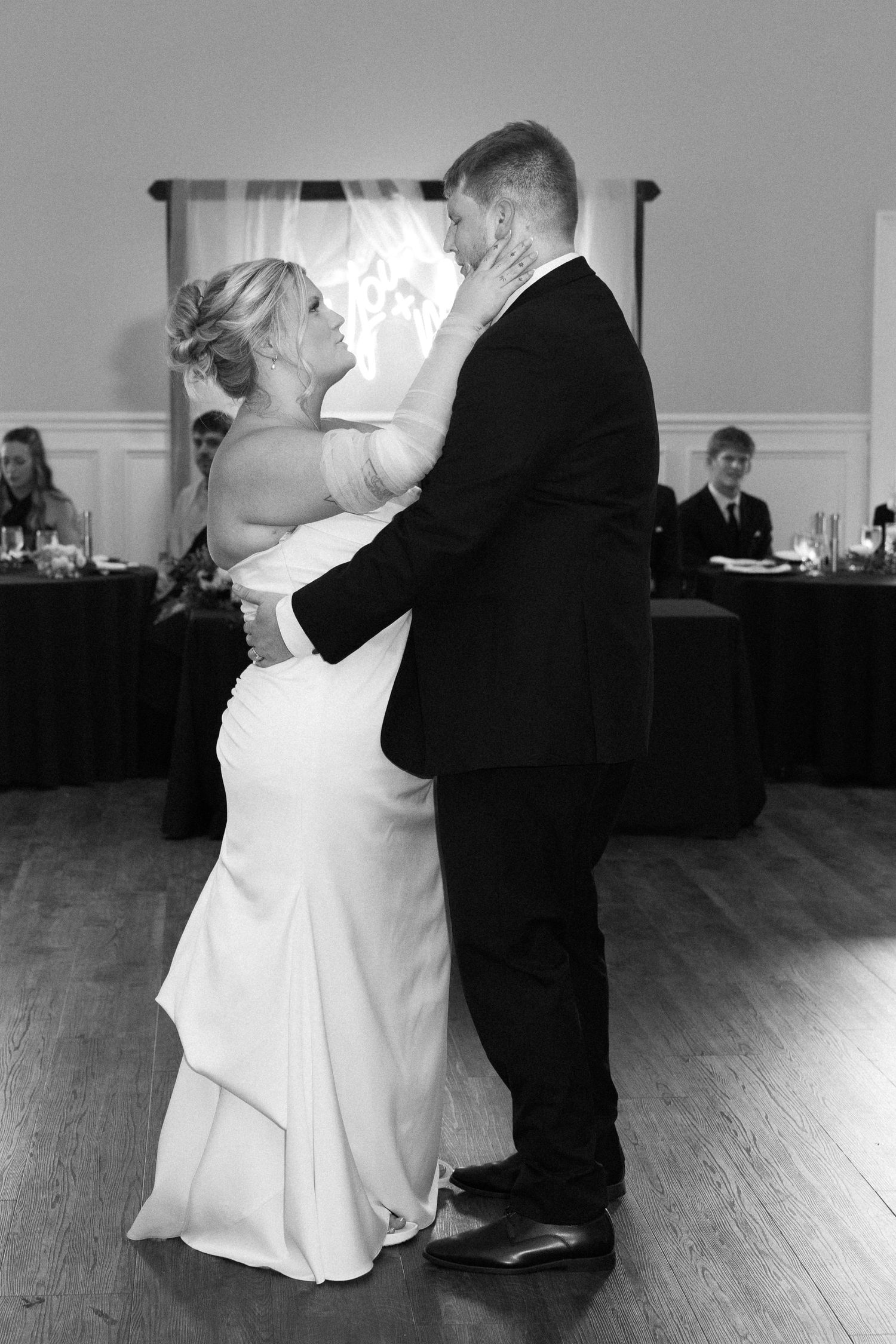 A couple shares their first dance at their wedding reception on a wooden dance floor. Located in Bellbrook, Ohio.