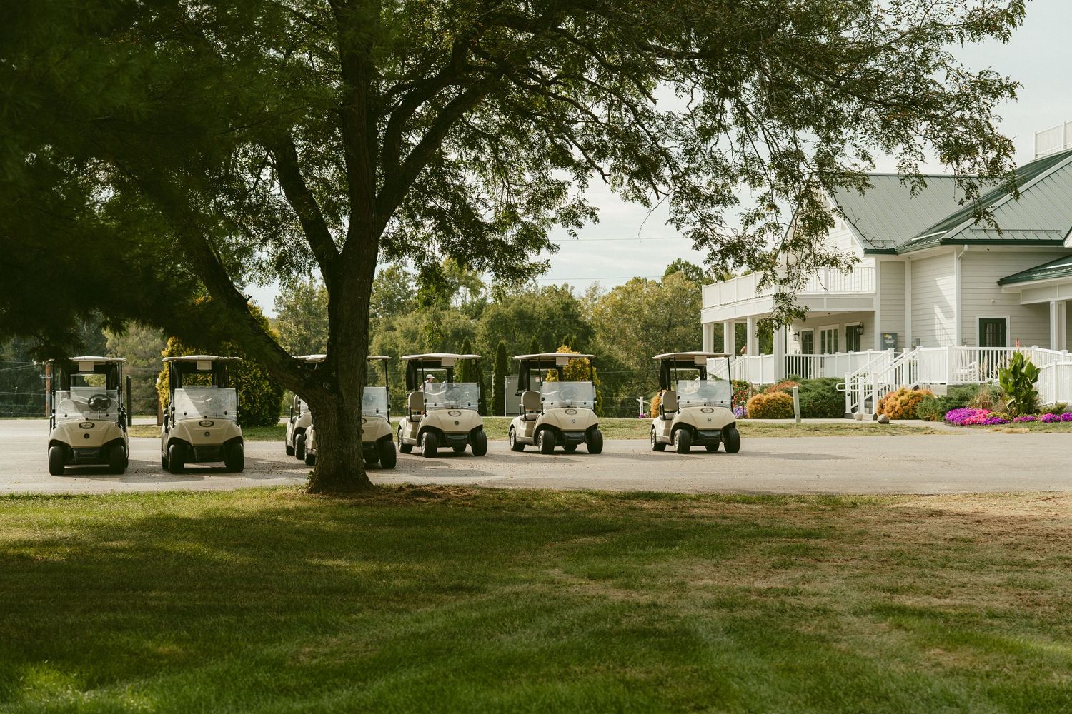 A panoramic view of a rural farmhouse property with green lawn, trees, and parked vehicles in the distance. Located in Bellbrook, Ohio.