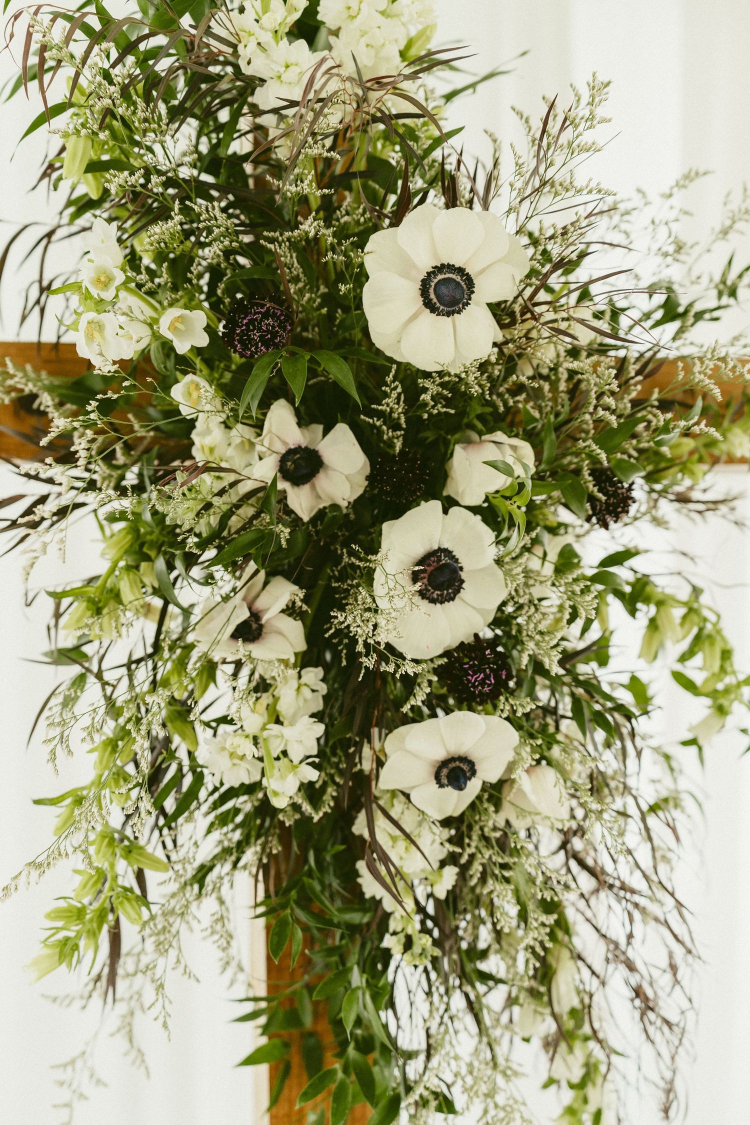 Elegant white anemone flowers arranged with delicate greenery and ferns in a cascading wedding bouquet style. Located in Bellbrook, Ohio.