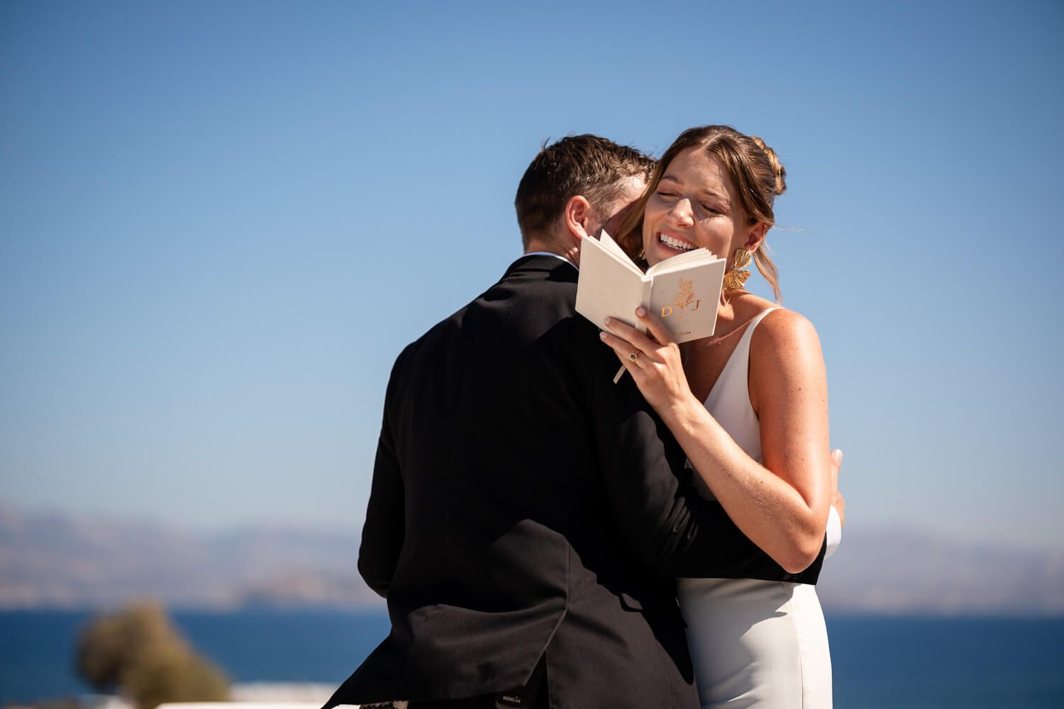 Romantic couple embracing on the roof of a Paros destination wedding venue