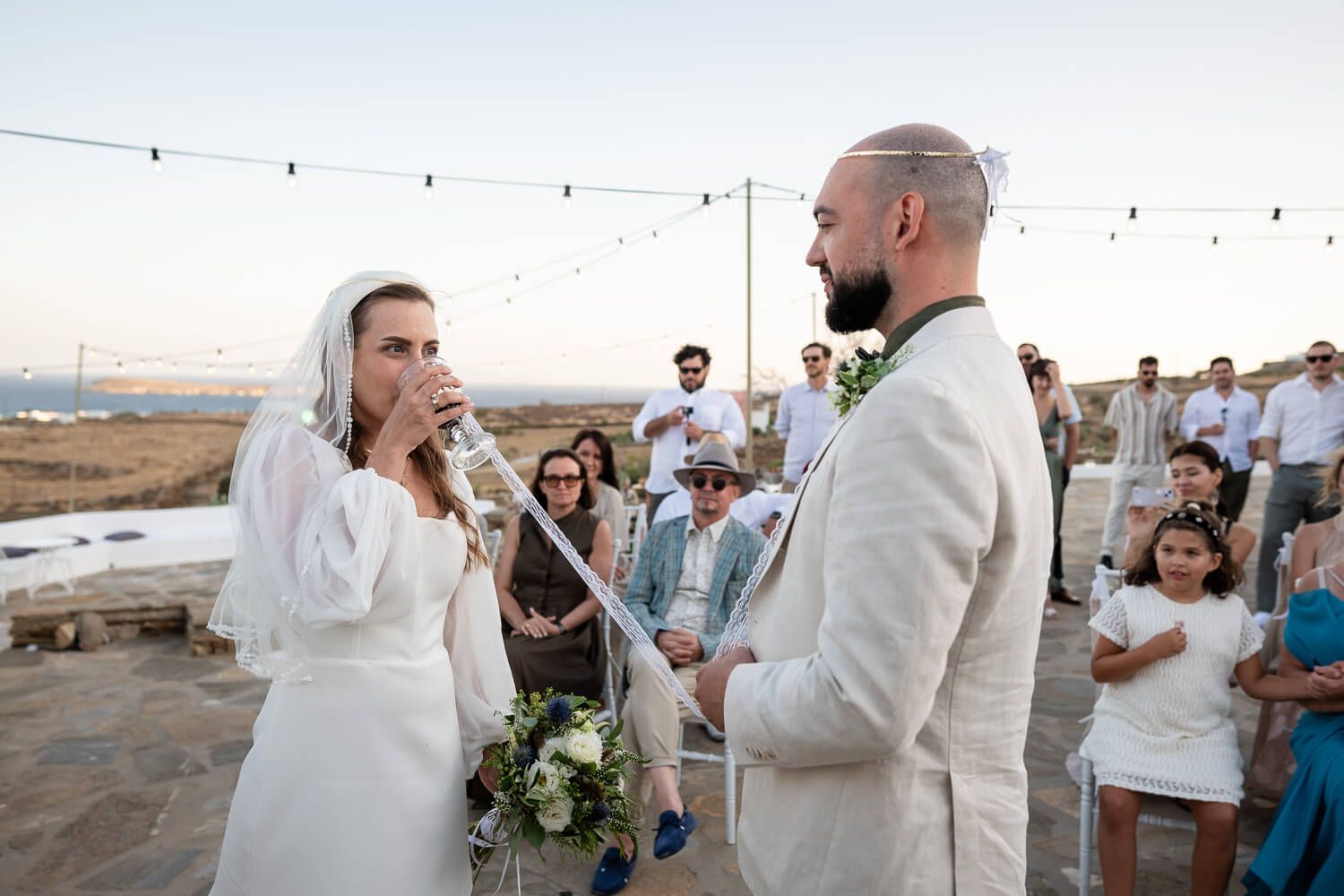 The couple sharing wine from a common cup, a beautiful Greek wedding tradition