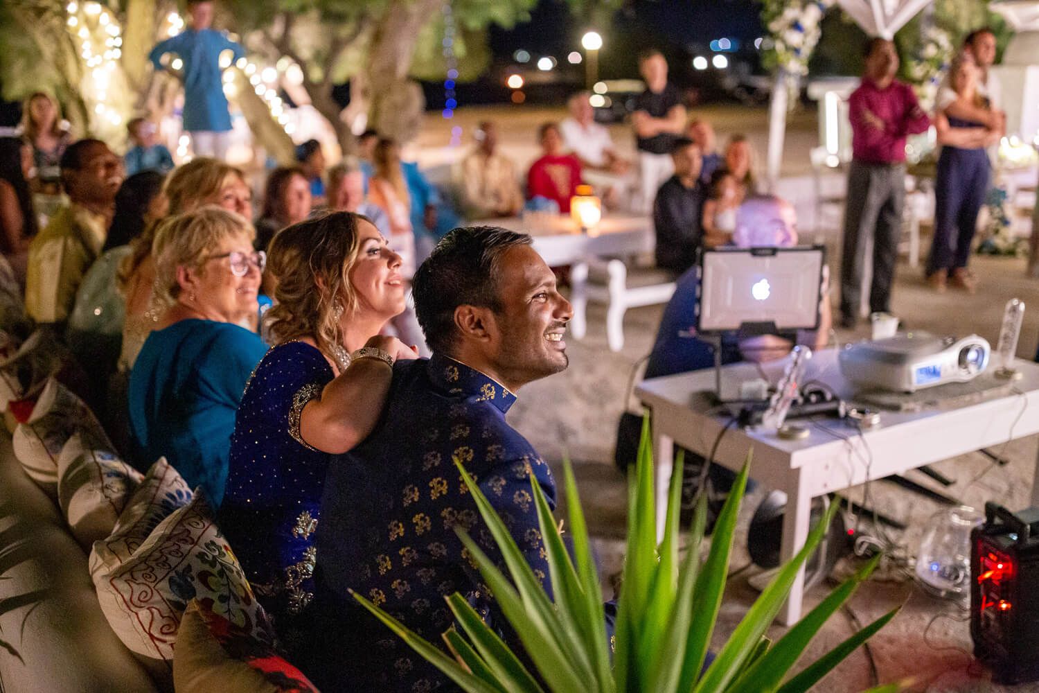 Bride and groom laughing during a surprise wedding slideshow in Paros