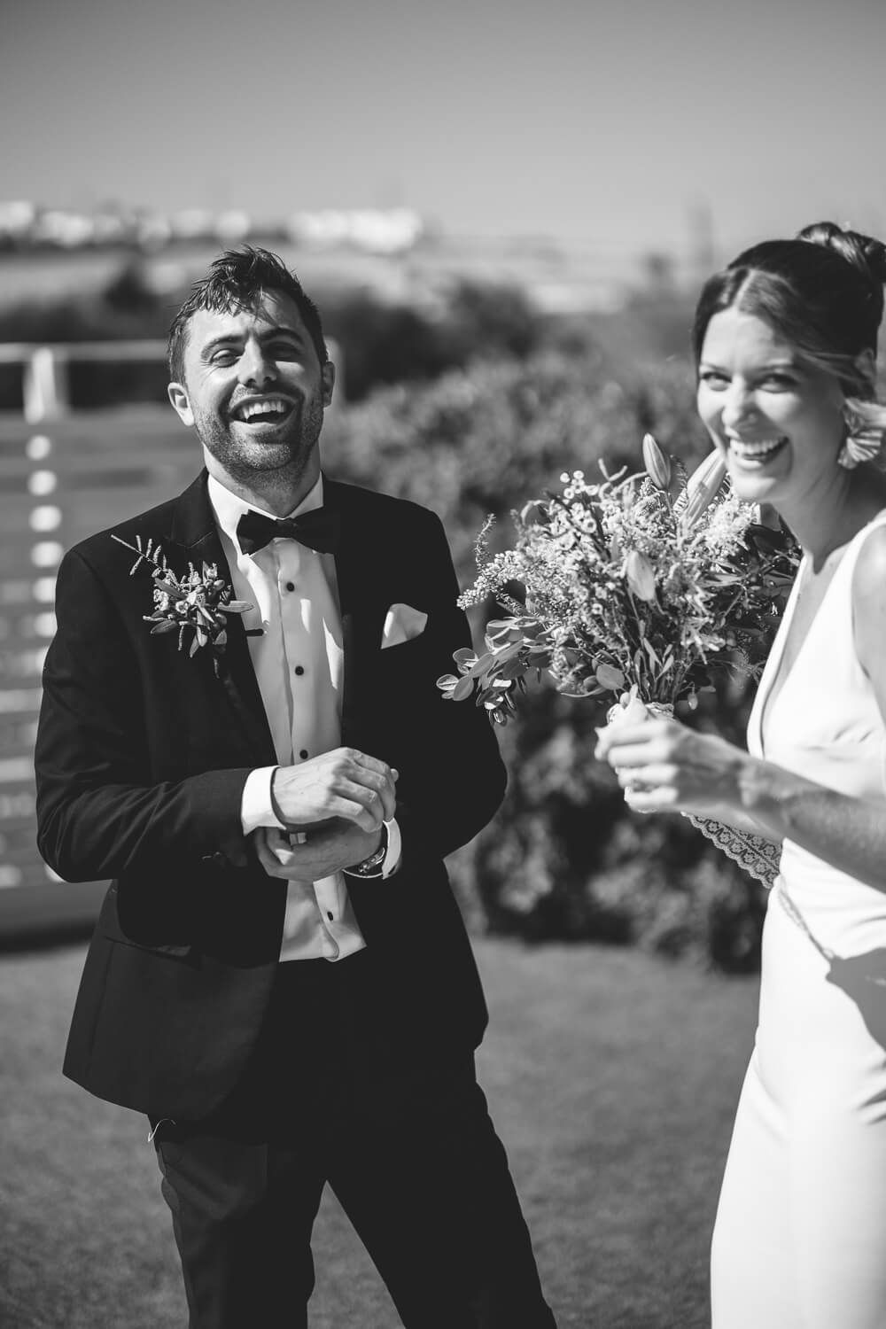 Jess and Daniel laughing in the courtyard of their Paros wedding villa
