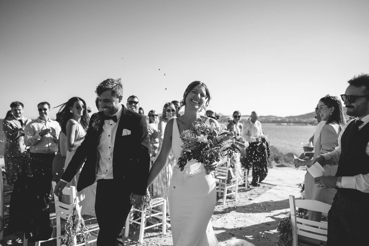 Happy UK guests throwing petals at the bride and groom in Greece