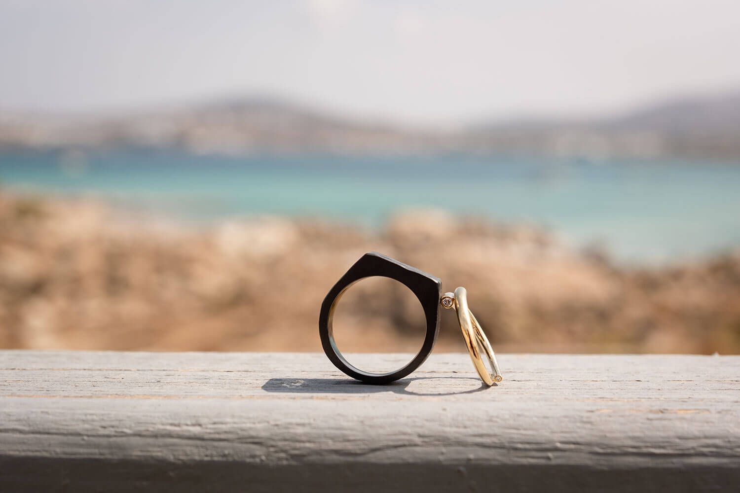 Wedding rings resting on Mediterranean greenery before a Paros elopement