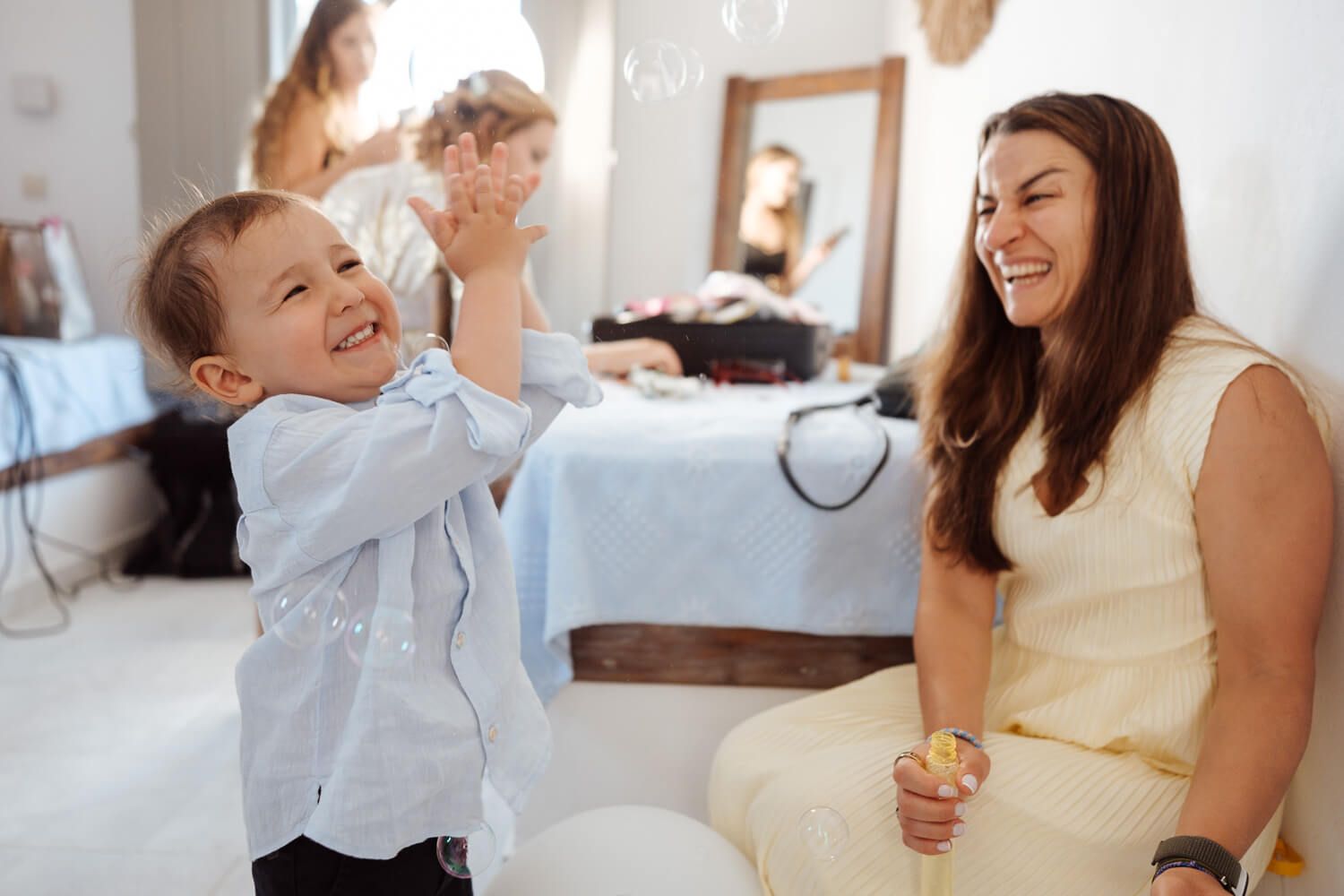 Candid laughter among friends during bride preparations in the Cyclades