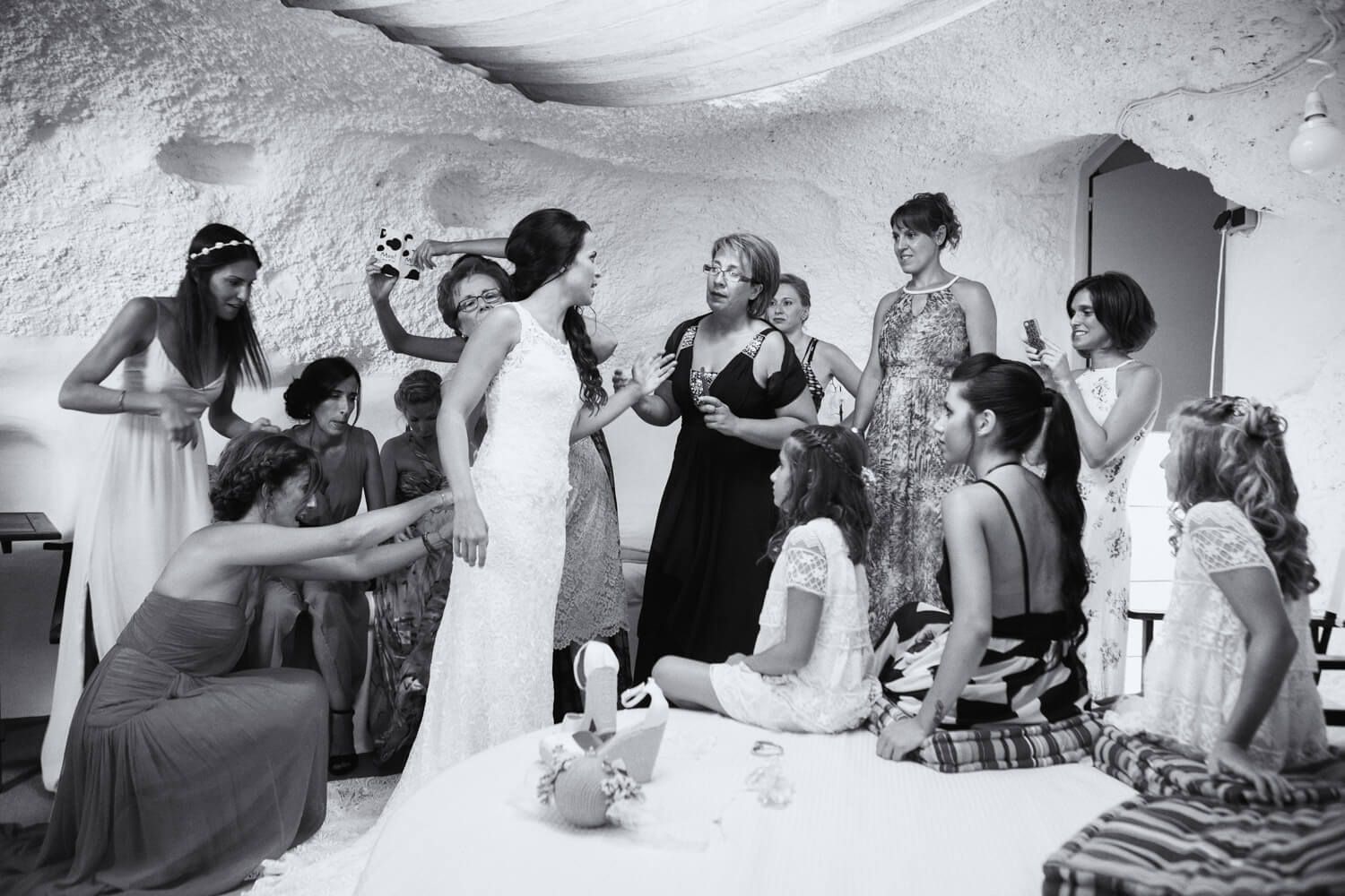 Bride putting on her wedding dress inside a restored cave house
