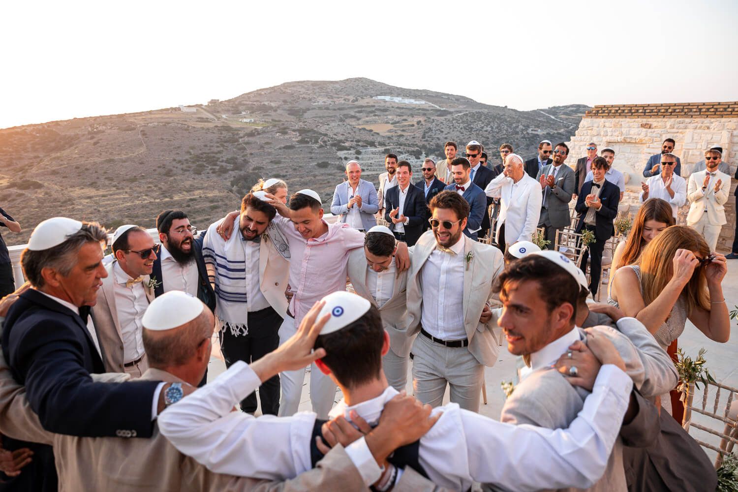 Guests dancing in circles after jewish wedding ceremony in Paros