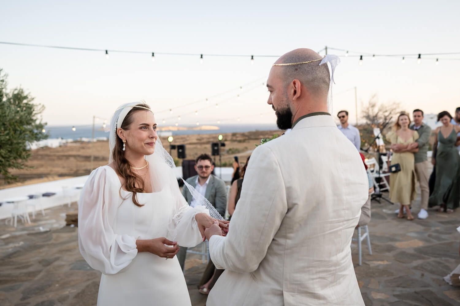 Exchanging of the wedding rings under the bright Paros sun