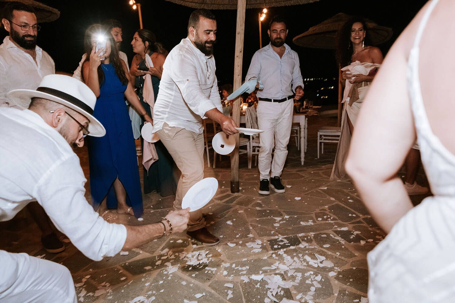 Traditional Greek plate smashing at a wild Paros wedding celebration
