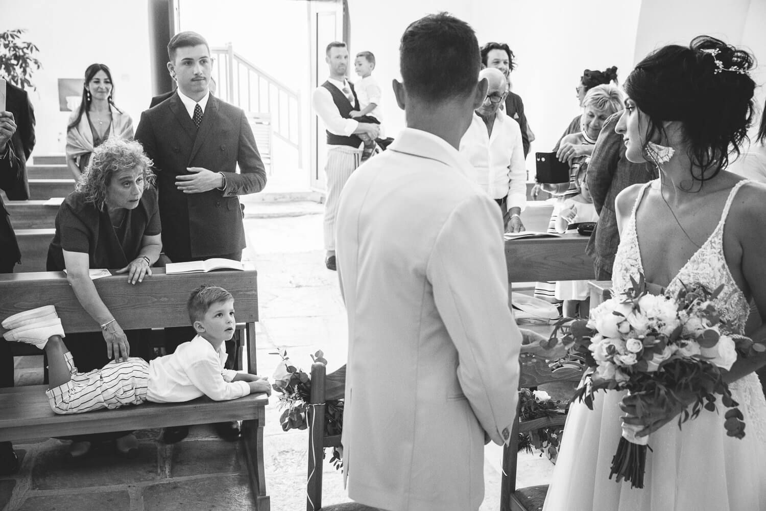 Wide angle shot of the wedding ceremony inside the beautifully lit Catholic church
