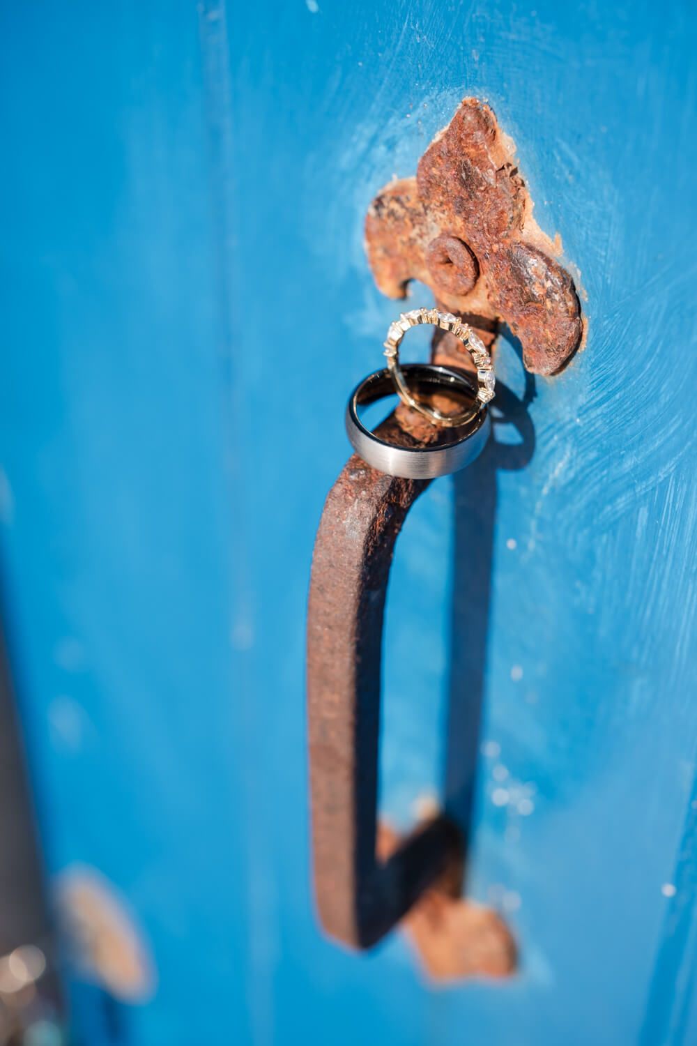 Wedding rings resting on a door handle at a Greek island villa
