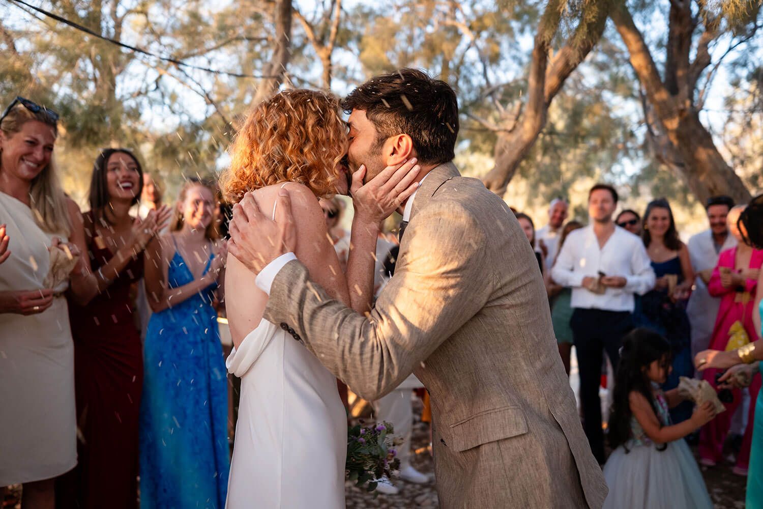 The newlyweds sharing their first kiss on the beach in Paros
