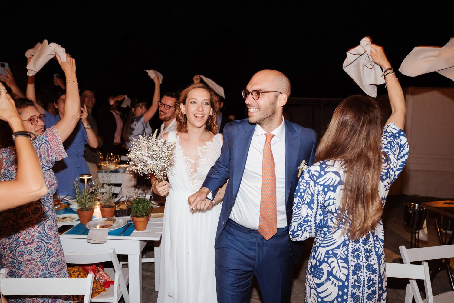 Guests cheering as Dimitris and Ioanna arrive at their Paros wedding reception