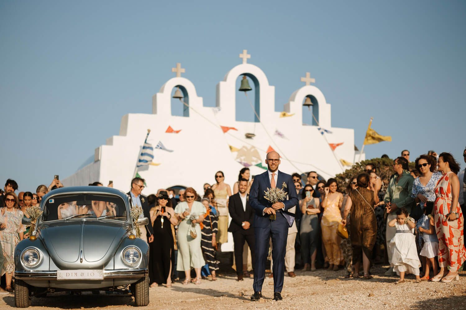 Groom waiting for his bride outside a traditional Cycladic chapel