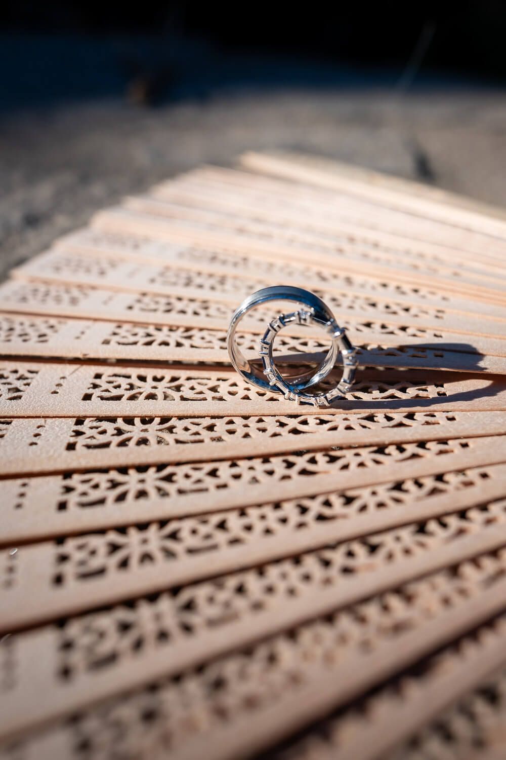 Close up of the wedding rings resting on a rustic table at Petra Farm