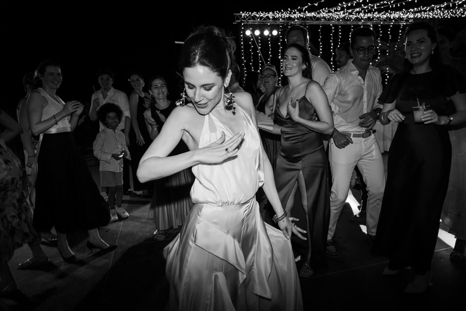 Bride Dimitra dancing enthusiastically with her bridesmaids
