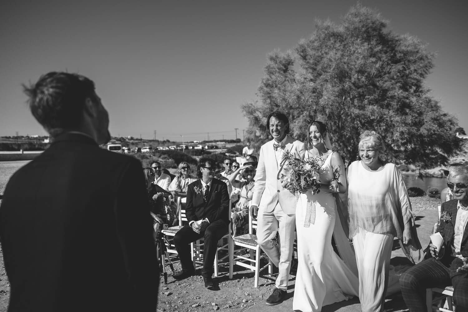 Groom waiting by the ocean for his bride to arrive in Greece