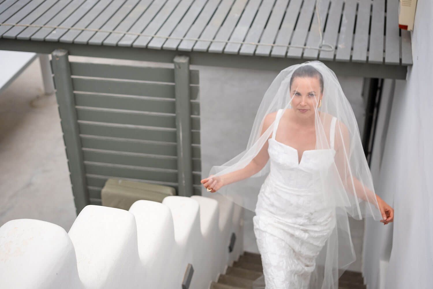 Bride walking down the aisle on a rooftop overlooking Kolimbithres