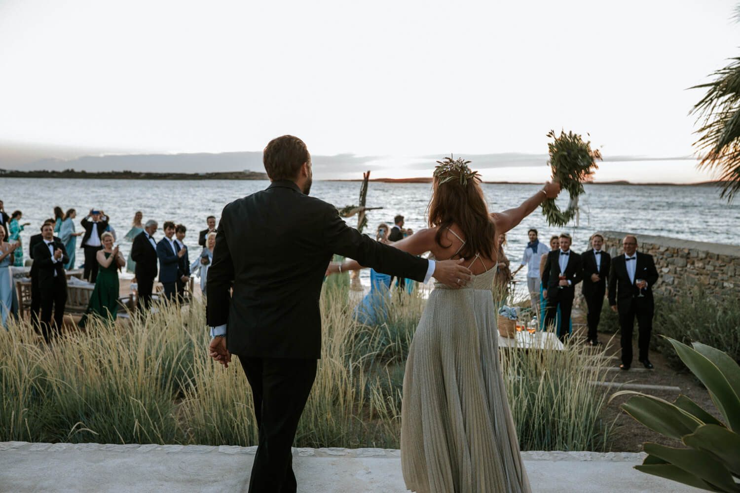 Newlyweds make grand entrance at outdoor waterfront wedding reception at Seesoo Hotel Paros.