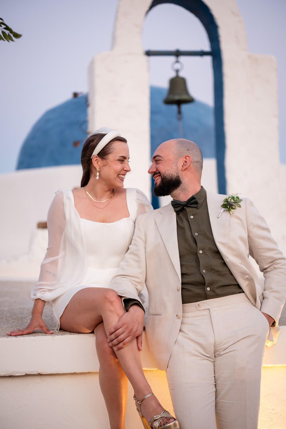 Bride and groom looking at each other in front of a chapel at the Secret View Venue in Paros Island