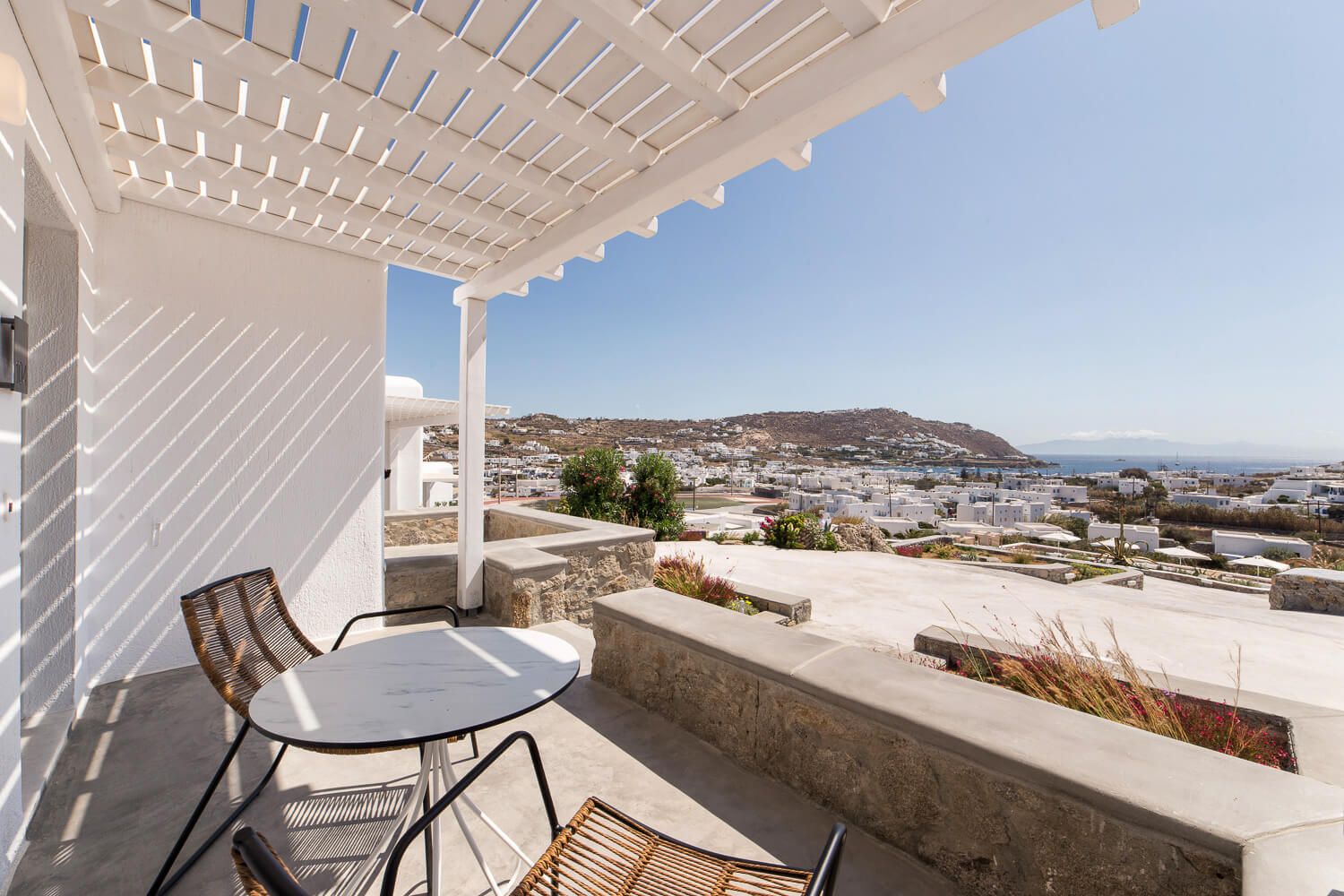 Contemporary exterior lounge setups with elegant shading solutions in Mykonos island