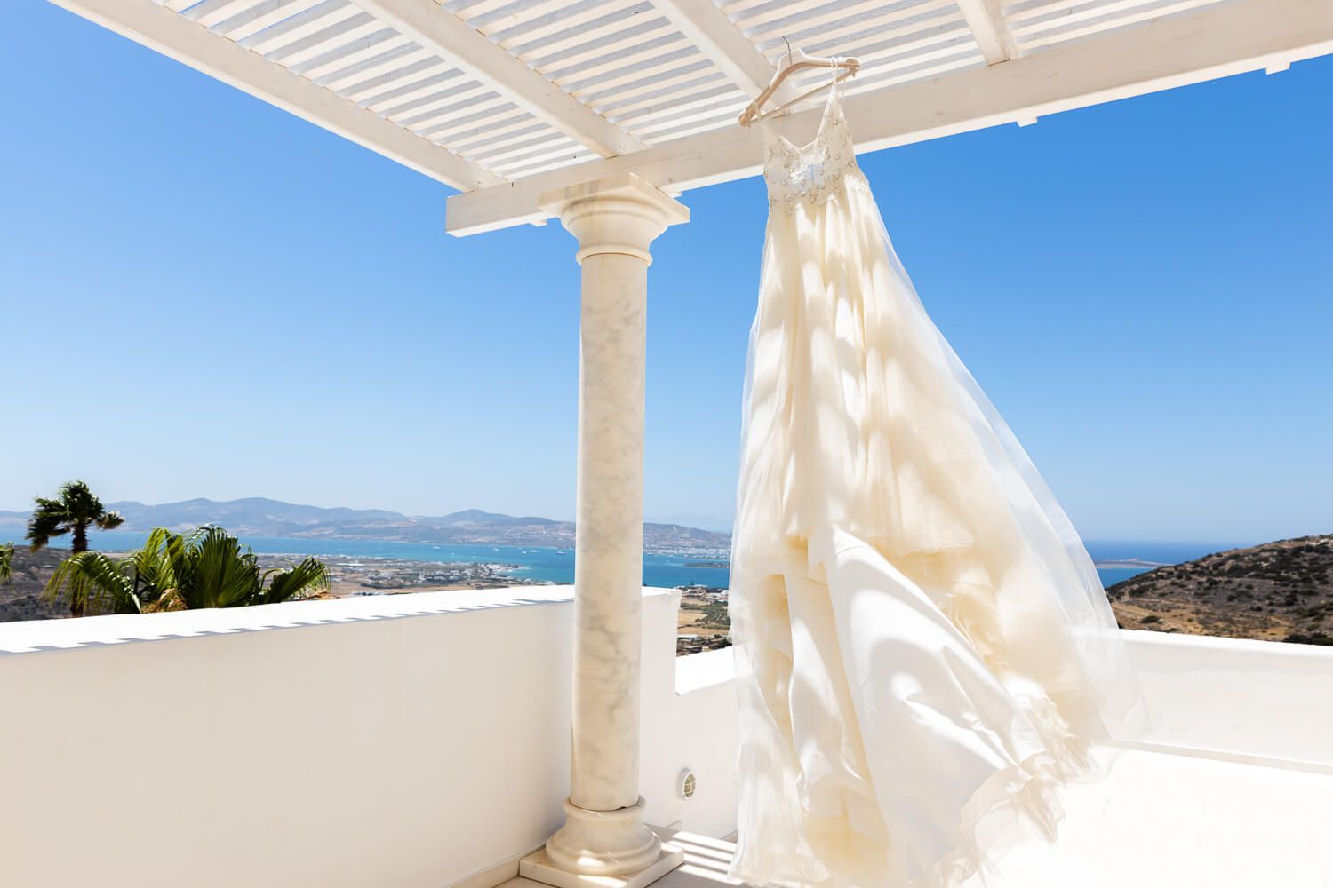 Stunning wedding dress hanging in a traditional Cycladic bedroom at Villa Aethra