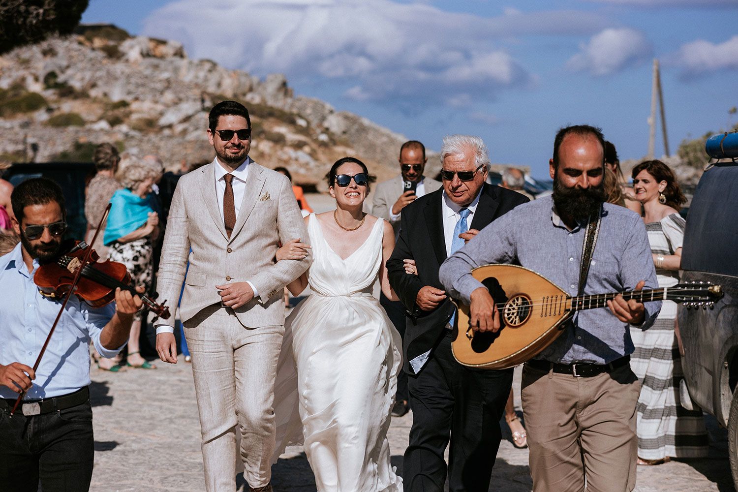 The bride is heading to the church acompanied by local musicians in Aigiali Amorgos