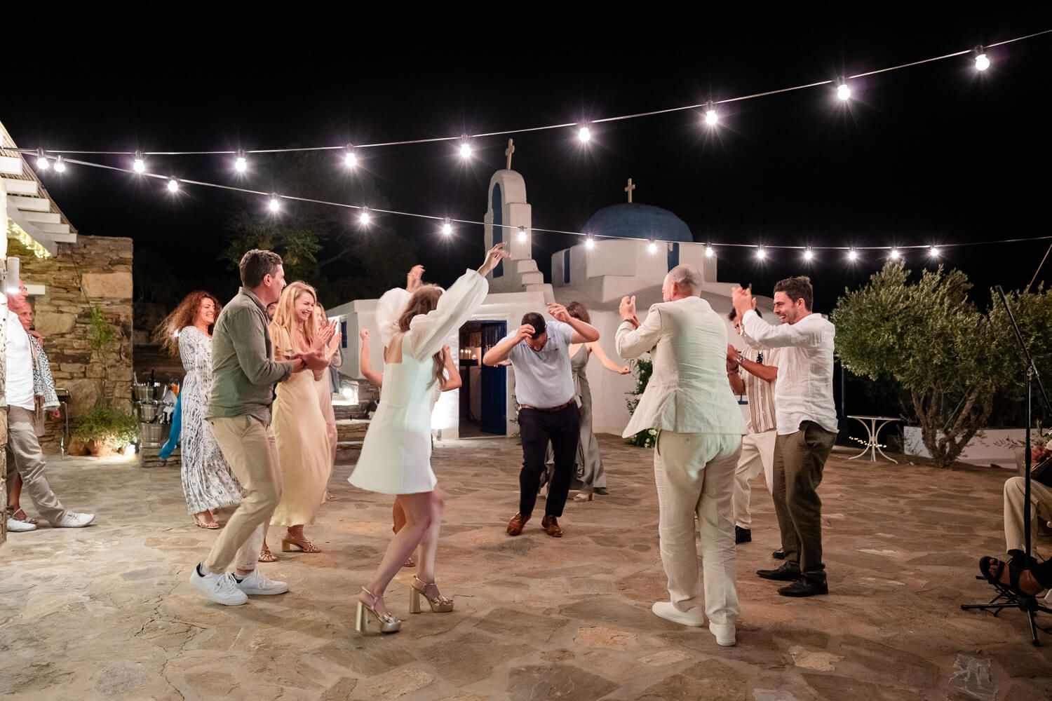 High-energy wedding party starting with traditional Greek island dancing