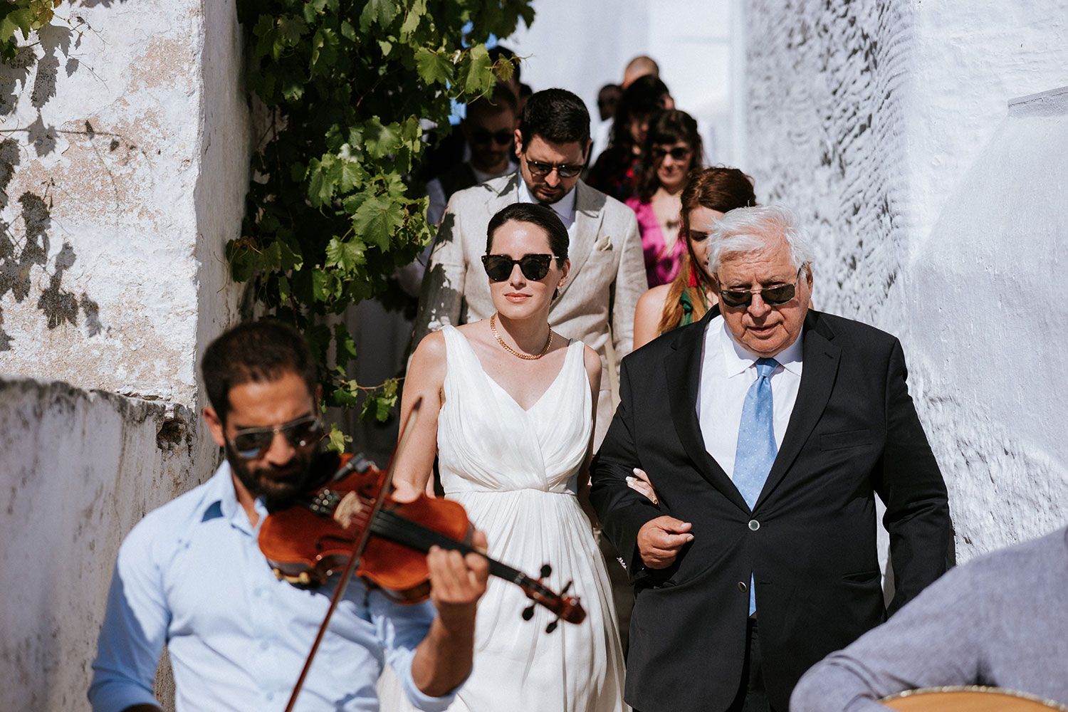 The bride is heading to the church acompanied by local musicians in Aigiali Amorgos