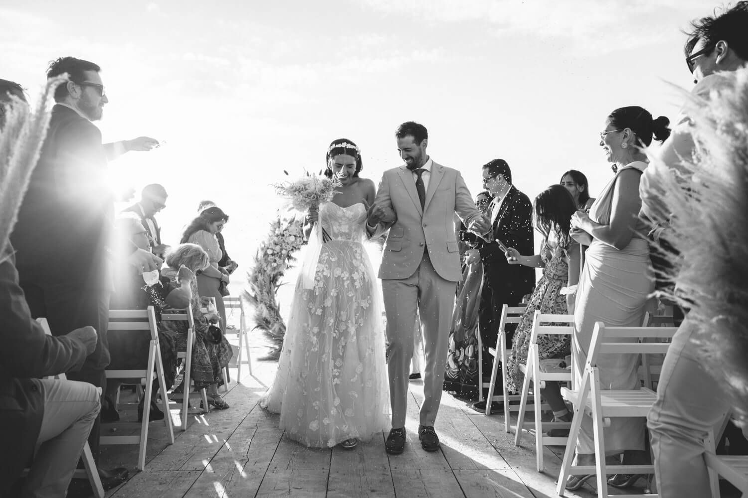 Newlyweds walking down the aisle at the seaside Seesoo venue