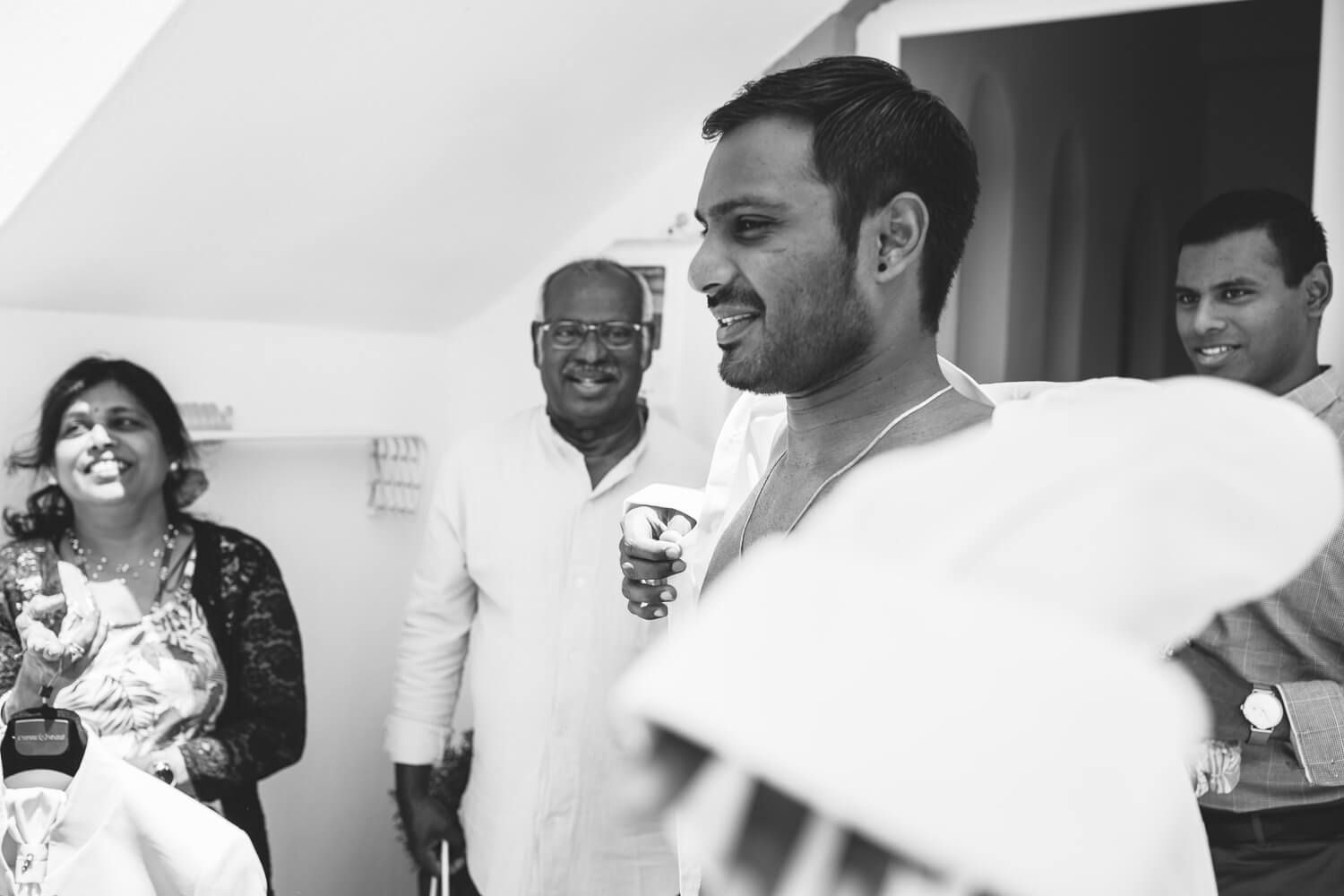 Groom sharing a laugh with friends during wedding prep in the Cyclades
