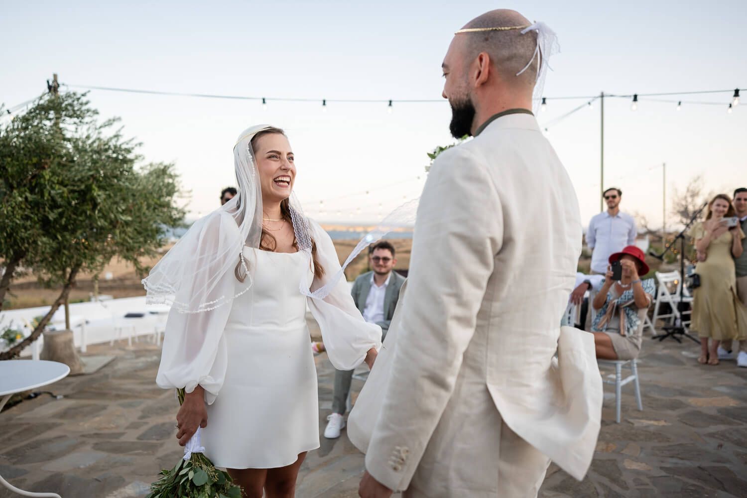Exchanging of the wedding rings under the bright Paros sun